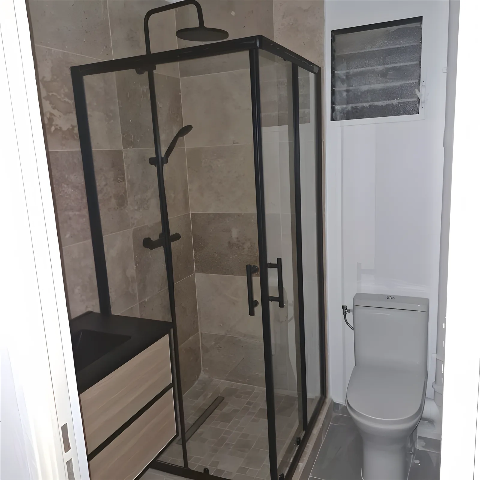 Salle de bain rénovée : douche vitrée à profilés noirs, meuble vasque et WC