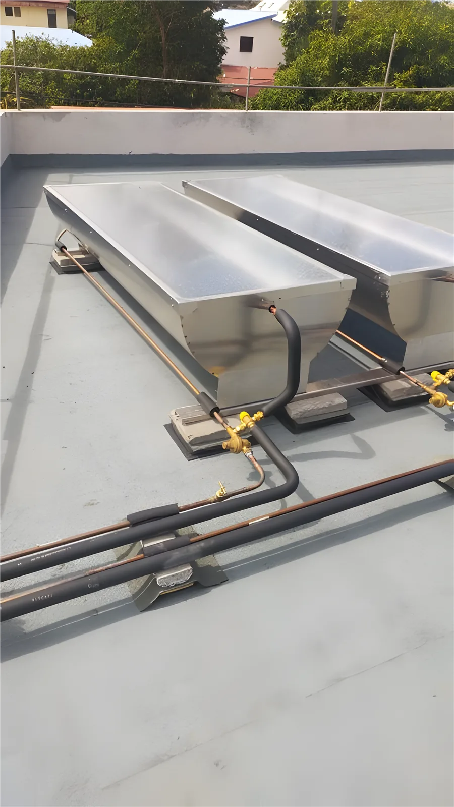 Deux chauffe-eau solaires raccordés sur un toit terrasse