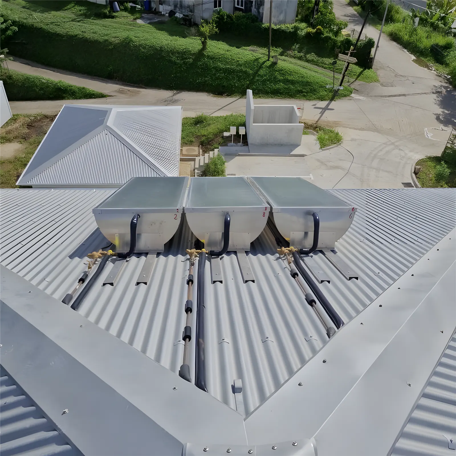 Trois chauffe-eau solaires sur une toiture en tôle alu